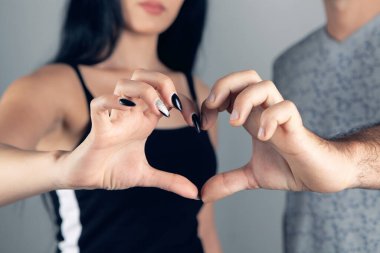 Erkek ve kadın elleriyle yüreklerini gösterirler.