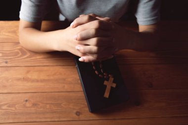 Kadın haç tutarak dua ediyor