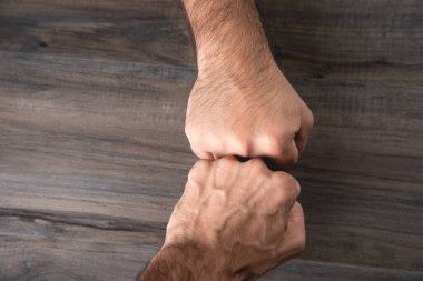 Erkek yumrukları ahşap arka planda dostça dokunur