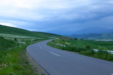 Akşamları asfalt bir yol tarlalardan geçer.