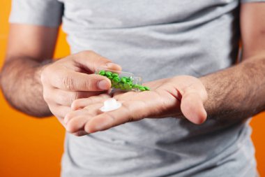 Bir adam eline hap verir.