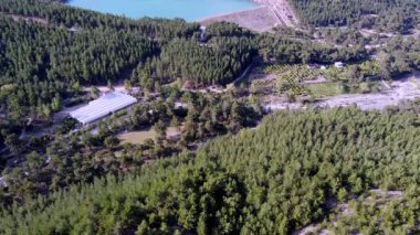 Zümrüt bir dağ gölünün üzerinden uçarak dağlar ve eko-çiftlikte organik ürünlerin yetiştiği seraların üzerinden geçen bir dağ nehri.