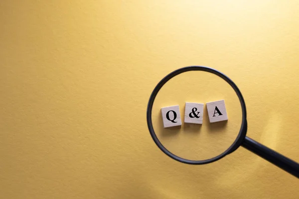 Büyüteç, Q & A ahşap alfabe harfine odaklanıyor. Soru ve cevap kavramı