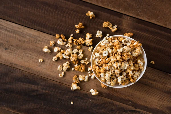 caramel popcorn on wooden table background. caramel flavoured popcorn in bowl