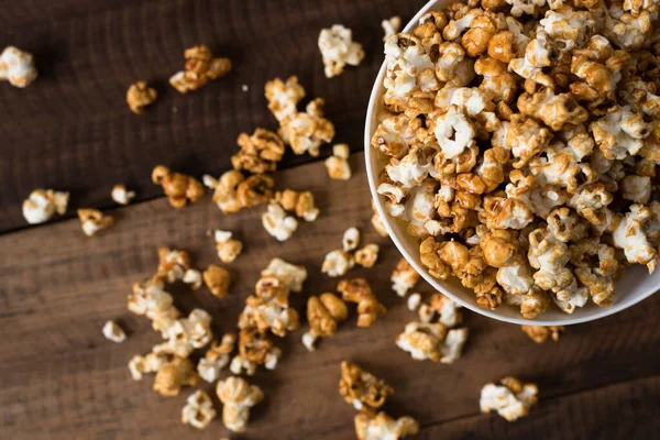 caramel popcorn on wooden table background. caramel flavoured popcorn in bowl