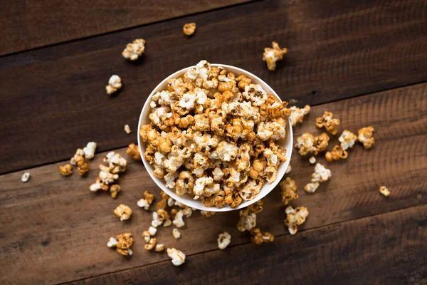 caramel popcorn on wooden table background. caramel flavoured popcorn in bowl