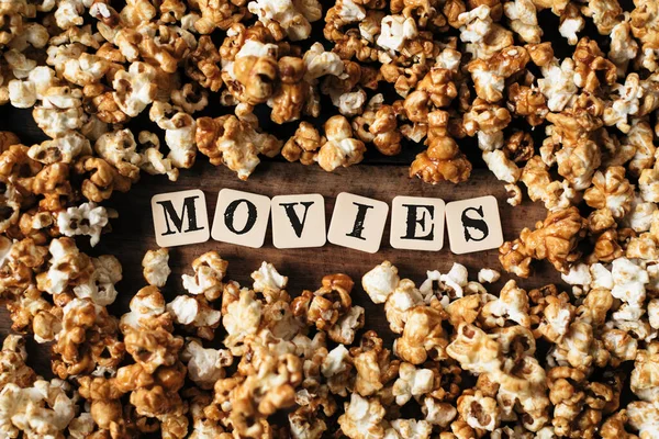 Tahta masadaki film sözcüğüyle taze patlamış mısır.