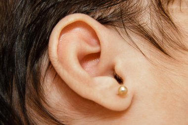 Küpeleri delen sevimli bir bebek.