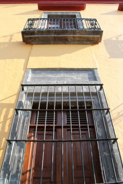 Büyük, eski bir pencere demirine yakın sarı bir antika ev tasarımı.