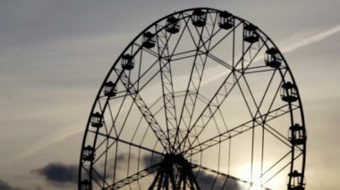 Akşam gökyüzünün arka planında dönme dolap.