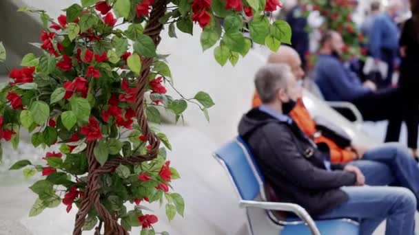 Two men are sitting on a bench in a business center. — Stock Video