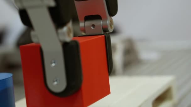 A robotic arm moves a cube-shaped part. — Stock Video