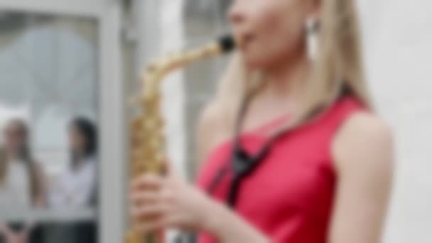 Het meisje speelt saxofoon.. — Stockvideo