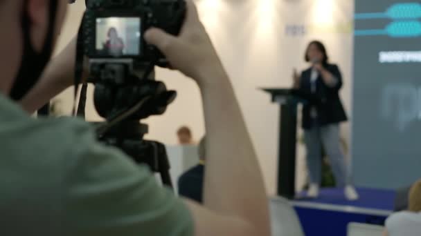 Um videógrafo está filmando os alto-falantes na sala de conferências. — Vídeo de Stock
