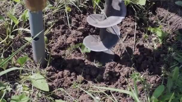 Perçage d'un trou dans le sol pour l'auto-installation de la clôture, gros plan — Video