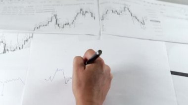 İnsan eli borsa grafiği çizer.