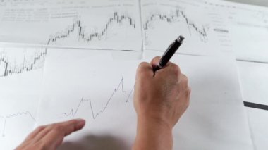İnsan eli borsa grafiği çizer.