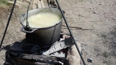 Doğanın arka planında, kaynayan sudan bir kazanda, bir ateşte pişirilmiş.