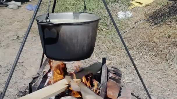 Kokta på bakgrunden av naturen på en brand i en gryta av kokande vatten — Stockvideo