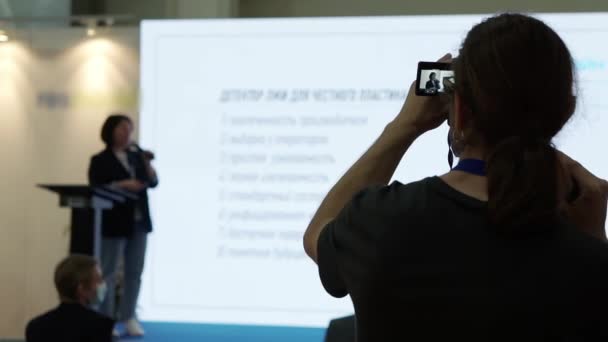 Um videógrafo está filmando os alto-falantes na sala de conferências. — Vídeo de Stock