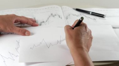 İnsan eli bir borsa çizelgesi çiziyor..