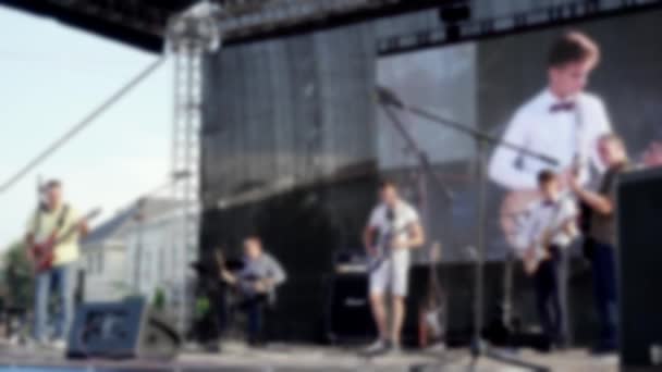 Defocused video of musicians performing on a street stage. — Stock Video