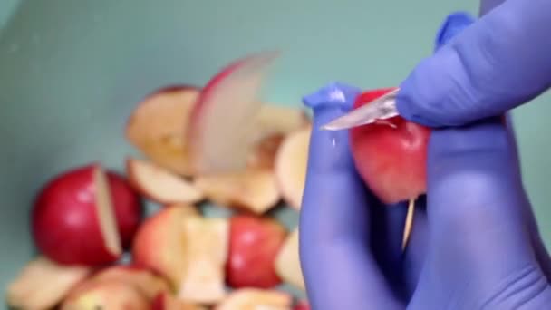 Cortar una manzana roja con un cuchillo. — Vídeo de stock