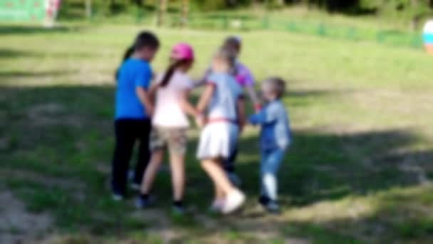 Niewyraźne wideo: Małe dzieci tańczące na zielonej trawie. — Wideo stockowe