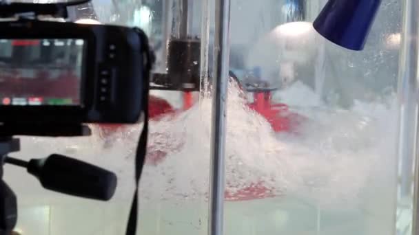 Μια βιντεοκάμερα σε τρίποδο καταγράφει την περιστροφή της υδραυλικής τουρμπίνας. — Αρχείο Βίντεο