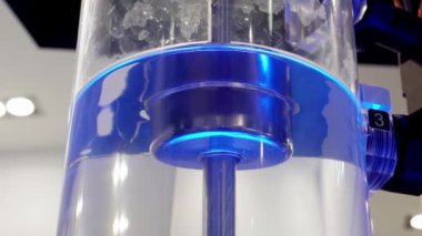 Şeffaf bir şişenin içine su pompalamak için pompalama.