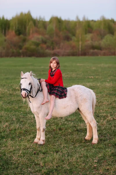 Signora cavalcando una ragazza bambino in un vestito cavalcando un cavallo bianco — Foto Stock