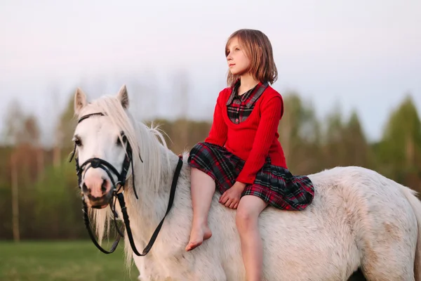 Klein kind zit in witte pony dacht en opzoeken — Stockfoto
