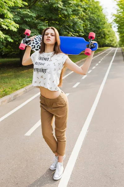 Retrato de uma jovem moda hipster que está segurando um skate para golovoy.Skateboarding. estilo de vida — Fotografia de Stock