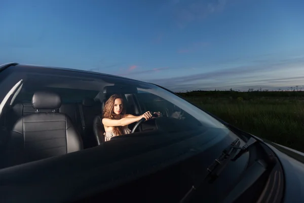 Молодая красивая девушка сидит за рулем автомобиля и собирается путешествовать на открытом воздухе — стоковое фото