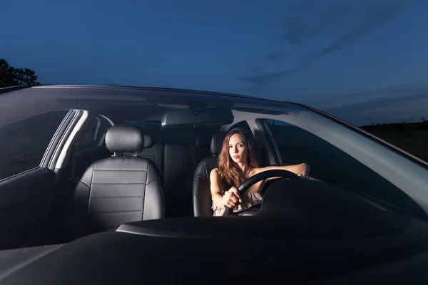 A beautiful young woman sits behind the wheel of the car and waiting passengers — Stock Photo, Image