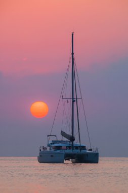 Güzel katamaran deniz gündoğumu arka plan üzerinde yelken