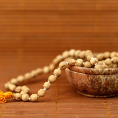 Budist dua boncukları ahşap arka planda bir kasede. Farkındalık veya meditasyon konsepti. Kapat, boşluğu kopyala.