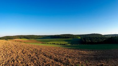 Tarım tarlasını sürmüş ve açık mavi gökyüzü Almanya 'daki vadide kopyalanmış alanla