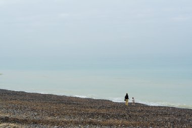 Bir kadın bir çocuk üzerinde bir çakıl plajı ile