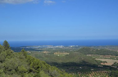 Dağın tepesinden aşağıdaki güzel manzaraya bak. Dağdan denize açıl. Yaz güneşinin altında yeşil bir ova. Dağ yürüyüşü.