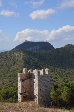 Dağın arka planına karşı antik bir kalenin kalıntıları. Yeşil dağ manzarası.