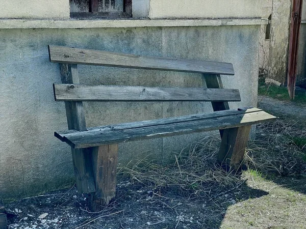 A mystical old wooden bench in an abandoned place. An unusual bench in an ordinary place. An old wooden bench.