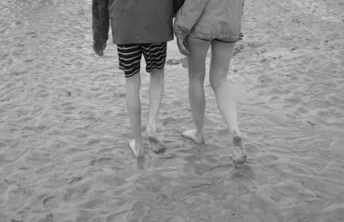 Mont Saint Michele Körfezi 'nde yürüyen iki kişinin bacakları.