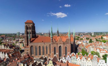 Polonya 'nın tarihi Gdask şehrinin hava panoramik manzarası, kırmızı kiremitli çatılar, hareketli yayalar ve güneşli bir yaz gününde çevreleyen yeşil manzara