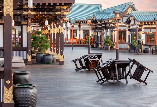 Bar masalarında ters dönmüş sandalyeleri olan kapalı açık hava kaldırım barı boş Japon şehri sokağı.