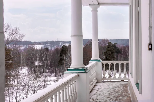 Evin ön verandası ve beyaz eski tarz sütunlar kış gökyüzünü kaplıyor. — Stok fotoğraf