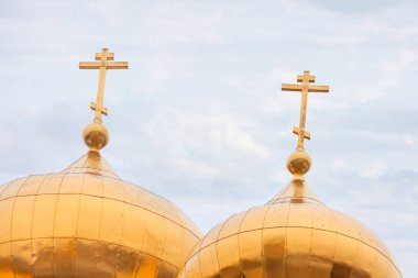 Kilise kubbesinin üstündeki altın haç paskalya ışığı arka planda.