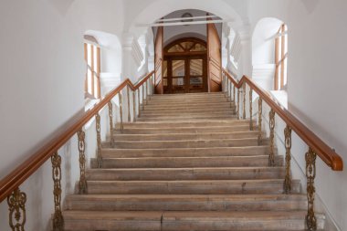 Ahşap tırabzanları ve beyaz duvarlı iç kalenin ön kapısı olan antik taş merdiven..