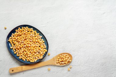 Black bowl chickpeas with wood spoon on white background, top view flat lay copy space. Vegan food and plant based food only concept.