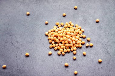 Gri beton arka planda siyah bezelye yığını, üstten düz görünüm kopya alanı. Vejetaryen gıda ve bitki bazlı gıda sadece konsept.